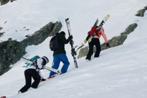 a group of people walking up the side of a snow covered slope